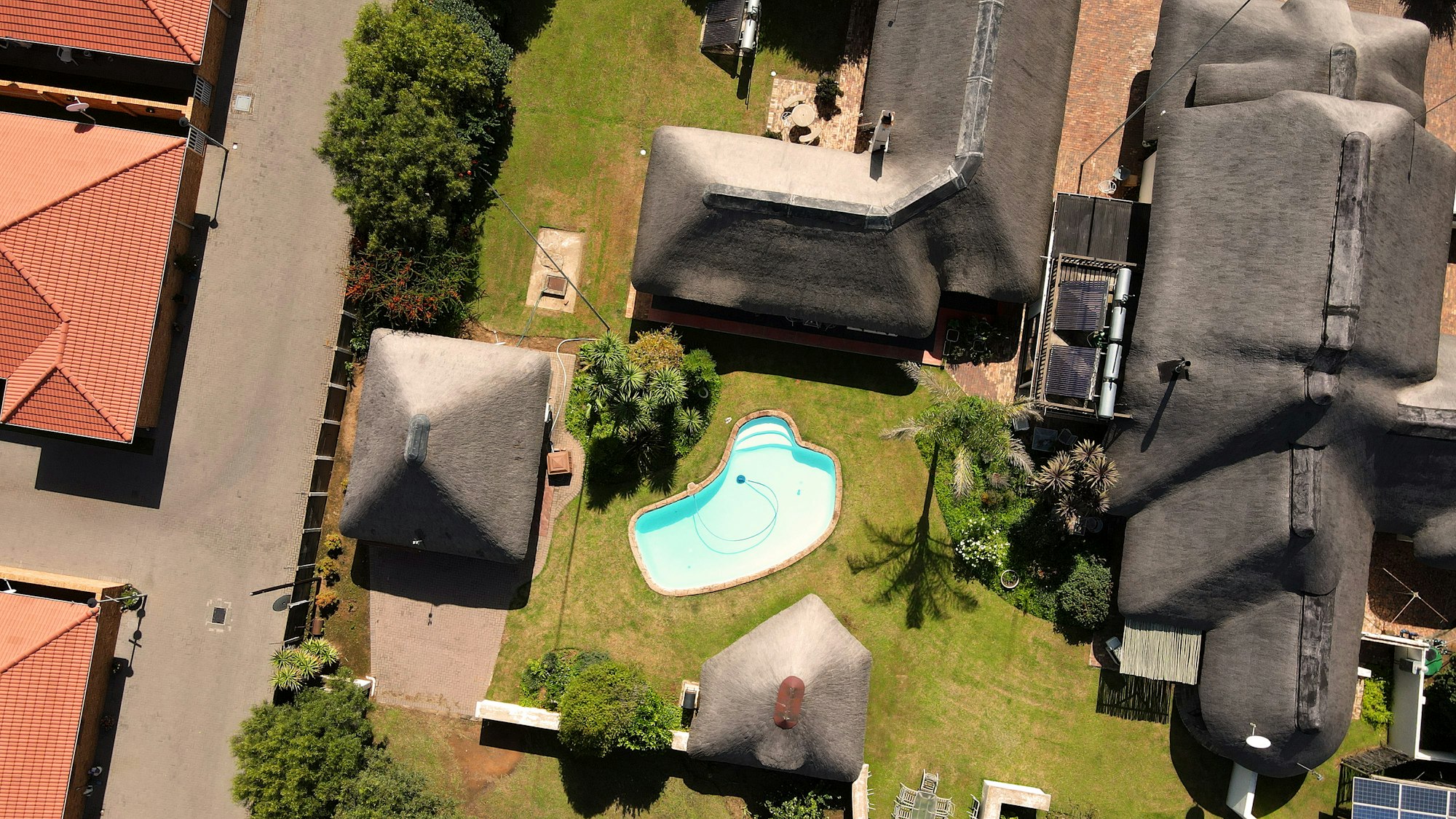 A South African guest-house compound with a pool, seen from above — place kin, not this roof